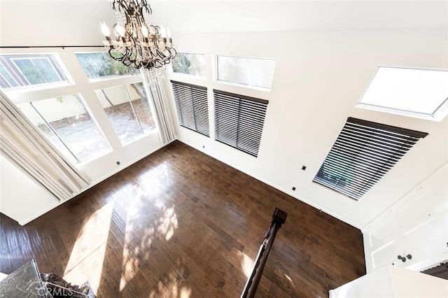 127 Lessay, Newport Coast, CA 92657 - unfurnished dining area with a chandelier, a high ceiling, and dark wood-style flooring
