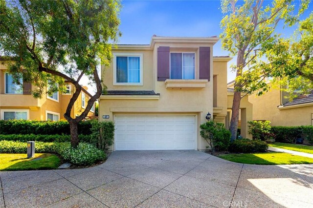 127 Lessay, Newport Coast, CA 92657 - view of front of house featuring an attached garage, stucco siding, and driveway