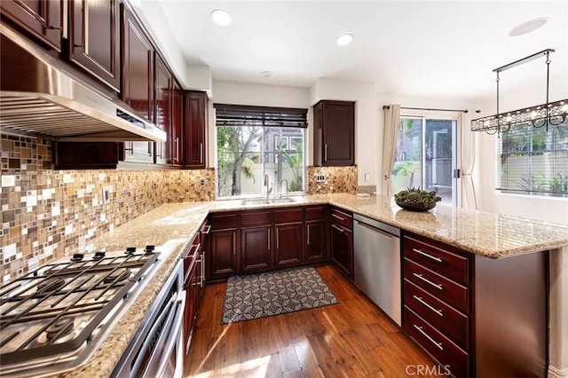 127 Lessay, Newport Coast, CA 92657 - kitchen featuring appliances with stainless steel finishes, under cabinet range hood, dark wood-style floors, a peninsula, and a sink