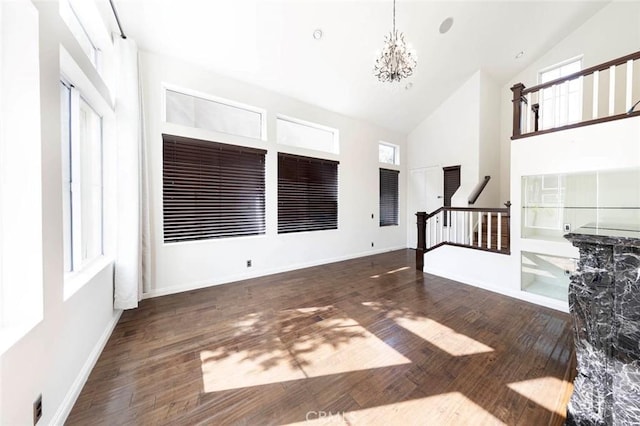 127 Lessay, Newport Coast, CA 92657 - unfurnished living room with high vaulted ceiling, wood finished floors, stairs, a chandelier, and baseboards