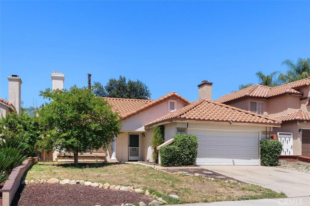 143 N Nebraska St, Lake Elsinore, CA 92530 - mediterranean / spanish-style home featuring a garage, concrete driveway, stucco siding, a tiled roof, and a chimney