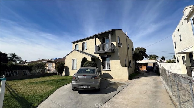 view of front of house featuring a balcony and stucco siding