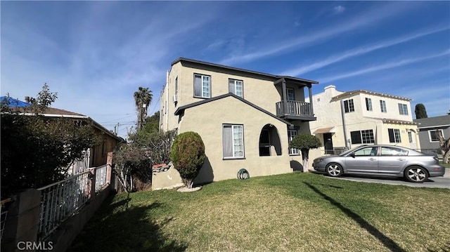 view of front facade featuring stucco siding and a balcony