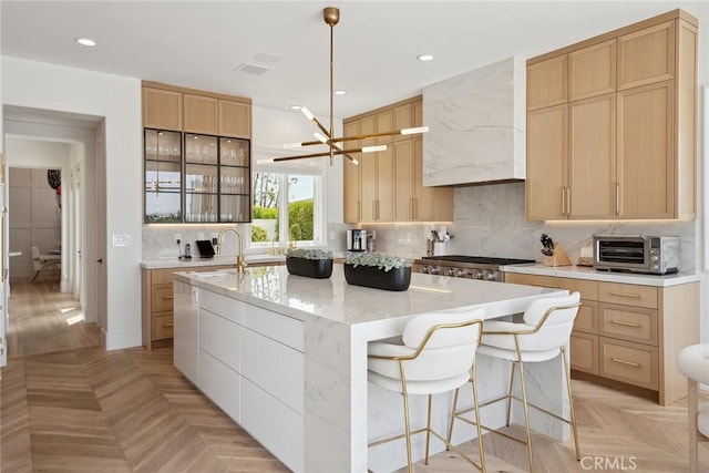 4177 Prado De Los Pajaros, Calabasas, CA 91302 - kitchen with a center island with sink, light brown cabinetry, custom exhaust hood, tasteful backsplash, and recessed lighting
