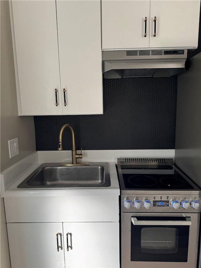 28691 Via Las Flores Unit 326, Murrieta, CA 92563 - kitchen with electric range, under cabinet range hood, white cabinetry, and light countertops