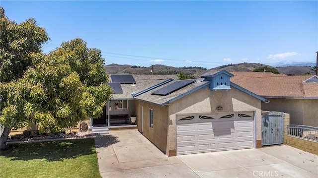 2271 Kellogg Park Dr, Pomona, CA 91768 - view of front of property with driveway, an attached garage, stucco siding, and roof mounted solar panels