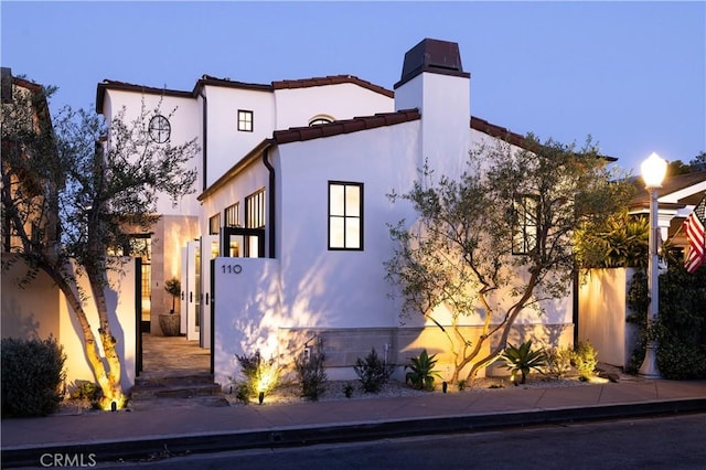 110 Via Orvieto, Newport Beach, CA 92663 - mediterranean / spanish-style house featuring stucco siding, a chimney, and a tile roof