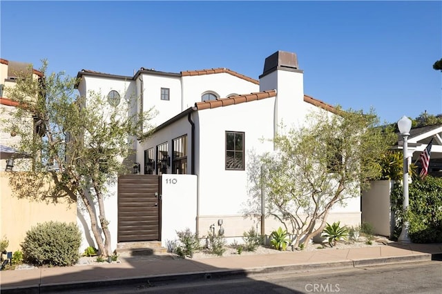 110 Via Orvieto, Newport Beach, CA 92663 - mediterranean / spanish-style house with a tiled roof, stucco siding, a chimney, and fence