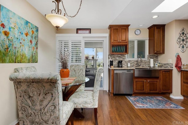3552 Bartlett Ave, Oceanside, CA 92057 - kitchen with stainless steel dishwasher, a sink, dark wood finished floors, tasteful backsplash, and a skylight