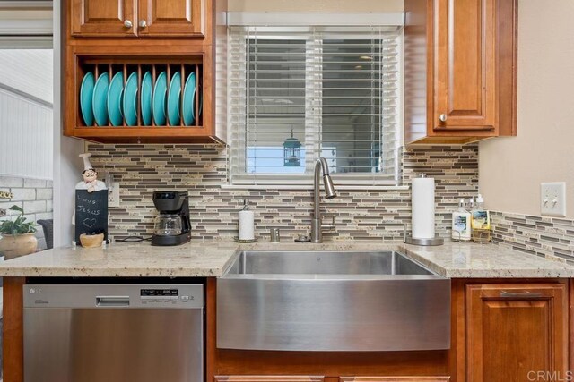 3552 Bartlett Ave, Oceanside, CA 92057 - kitchen with stainless steel dishwasher, a sink, decorative backsplash, light stone counters, and brown cabinetry
