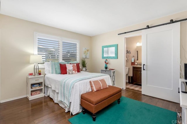 3552 Bartlett Ave, Oceanside, CA 92057 - bedroom featuring a barn door, dark wood finished floors, ensuite bathroom, and baseboards