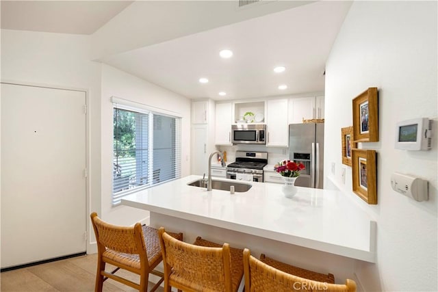 28107 Caldaro, Laguna Niguel, CA 92677 - kitchen with appliances with stainless steel finishes, a sink, a breakfast bar area, recessed lighting, and white cabinets