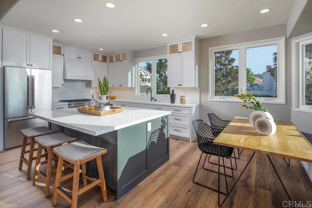 1808 Amalfi Dr, Encinitas, CA 92024 - kitchen featuring high quality fridge, custom exhaust hood, white cabinetry, glass insert cabinets, and recessed lighting