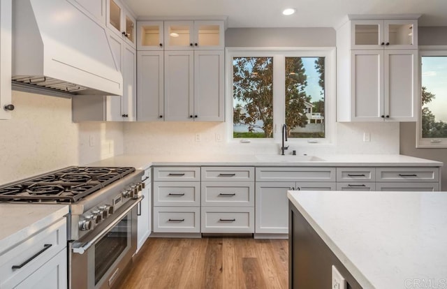 1808 Amalfi Dr, Encinitas, CA 92024 - kitchen with high end stove, premium range hood, white cabinets, light wood finished floors, and recessed lighting