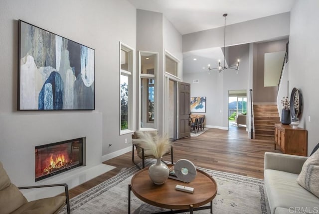 1808 Amalfi Dr, Encinitas, CA 92024 - living room featuring wood finished floors, stairs, a high ceiling, a chandelier, and a glass covered fireplace