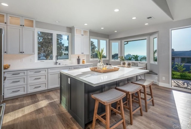 1808 Amalfi Dr, Encinitas, CA 92024 - kitchen with a breakfast bar area, light countertops, a kitchen island, recessed lighting, and dark wood-type flooring