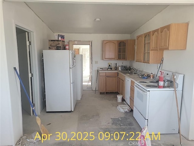 kitchen with white appliances, a sink, light brown cabinetry, and glass insert cabinets