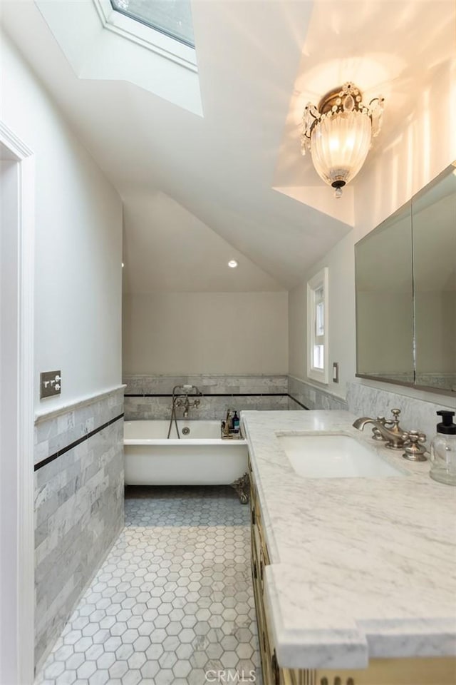 4225 Myrtle Ave, Long Beach, CA 90807 - full bath featuring tile walls, a skylight, a freestanding tub, vanity, and wainscoting