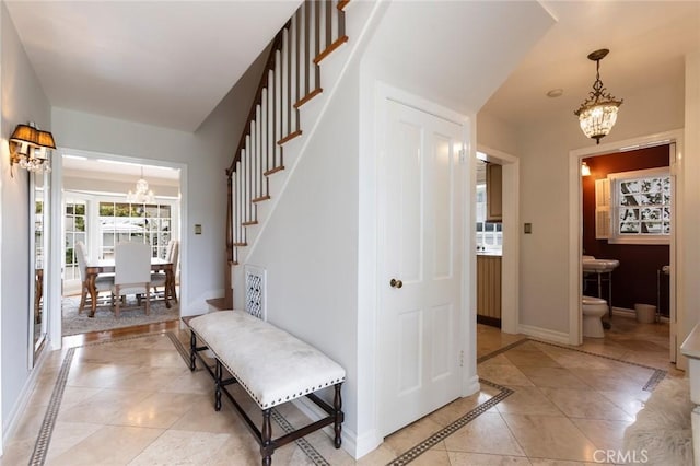 4225 Myrtle Ave, Long Beach, CA 90807 - entrance foyer featuring a chandelier, inlaid floor details, baseboards, stairway, and light tile patterned floors