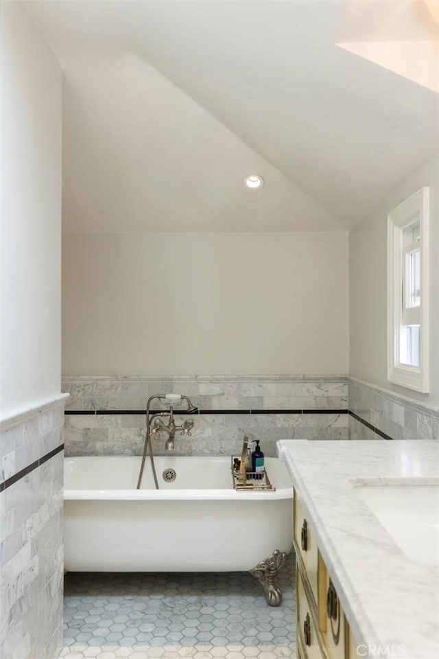 4225 Myrtle Ave, Long Beach, CA 90807 - bathroom featuring tile walls, tile patterned floors, wainscoting, a freestanding bath, and lofted ceiling