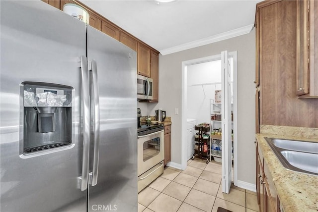 1980 Las Colinas Cir Unit 301, Corona, CA 92879 - kitchen featuring stainless steel appliances, crown molding, brown cabinetry, light tile patterned flooring, and light stone counters