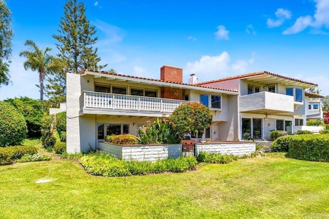 2117 Vista Entrada, Newport Beach, CA 92660 - back of house with a chimney, a balcony, stucco siding, and a lawn