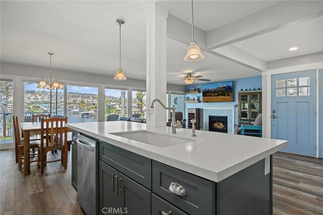 22244 Treasure Island Dr Unit 5, Canyon Lake, CA 92587 - kitchen with a sink, stainless steel dishwasher, a warm lit fireplace, open floor plan, and light countertops