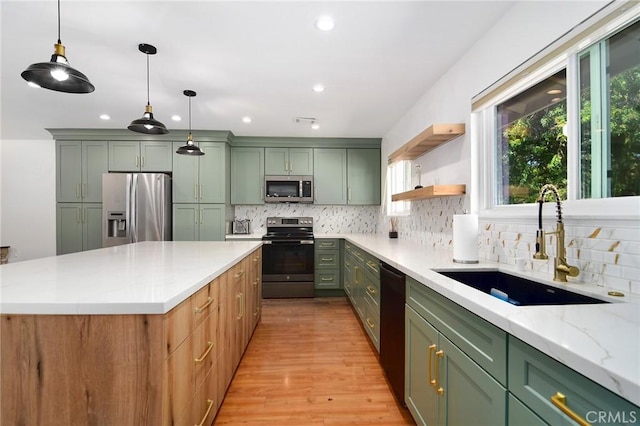 kitchen with stainless steel appliances, green cabinetry, a sink, backsplash, and recessed lighting