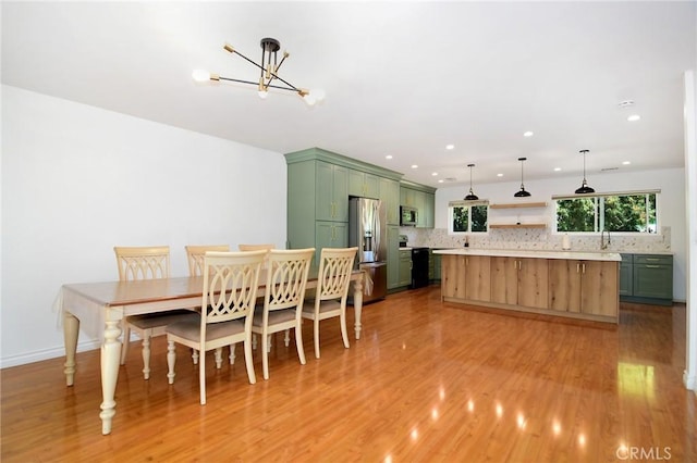 dining area with light wood-type flooring, a chandelier, recessed lighting, and baseboards