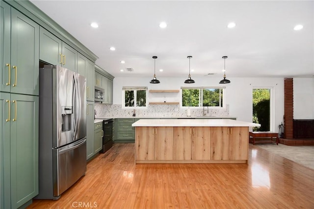 kitchen with stainless steel appliances, green cabinetry, light countertops, a center island, and recessed lighting