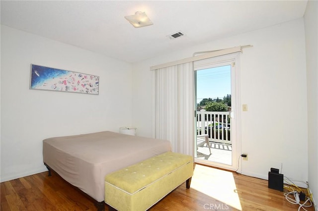 bedroom featuring access to exterior and wood finished floors