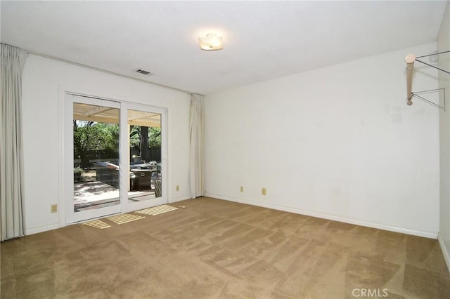 empty room featuring light colored carpet and baseboards
