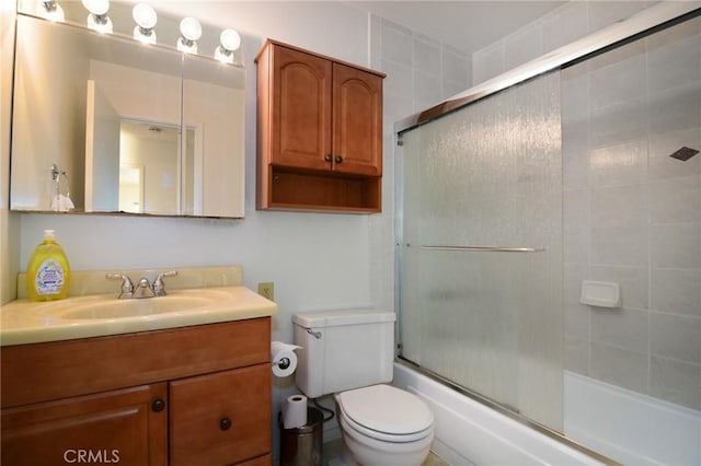 bathroom with toilet, vanity, and enclosed tub / shower combo