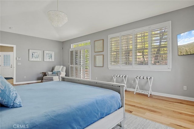 28537 N Shore Rd, Lake Arrowhead, CA 92352 - bedroom featuring wood finished floors, multiple windows, baseboards, and a chandelier