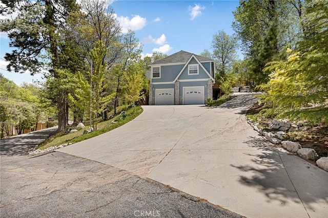 28537 N Shore Rd, Lake Arrowhead, CA 92352 - view of front of home featuring a garage, concrete driveway, and stone siding
