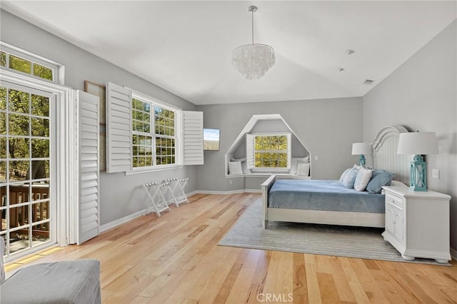 28537 N Shore Rd, Lake Arrowhead, CA 92352 - bedroom with wood finished floors, multiple windows, baseboards, a chandelier, and lofted ceiling
