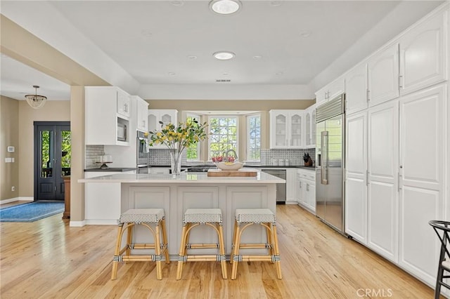 28537 N Shore Rd, Lake Arrowhead, CA 92352 - kitchen featuring stainless steel appliances, decorative backsplash, healthy amount of natural light, glass insert cabinets, and recessed lighting
