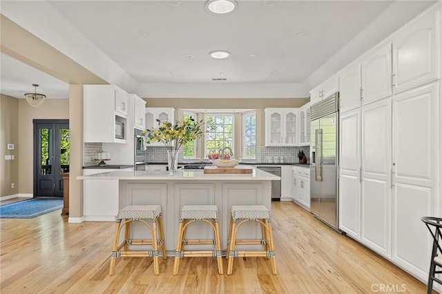 28537 N Shore Rd, Lake Arrowhead, CA 92352 - kitchen with built in appliances, backsplash, glass insert cabinets, healthy amount of natural light, and recessed lighting