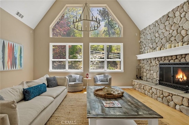 28537 N Shore Rd, Lake Arrowhead, CA 92352 - living area featuring a chandelier, high vaulted ceiling, wood finished floors, plenty of natural light, and a stone fireplace