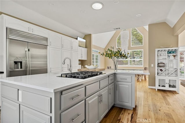 28537 N Shore Rd, Lake Arrowhead, CA 92352 - kitchen featuring gray cabinets, gas stovetop, built in fridge, vaulted ceiling, and light wood-type flooring