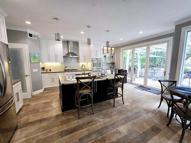 11610 Wills Creek Rd, San Diego, CA 92131 - kitchen featuring wall chimney exhaust hood, ornamental molding, wood finished floors, decorative backsplash, and a sink
