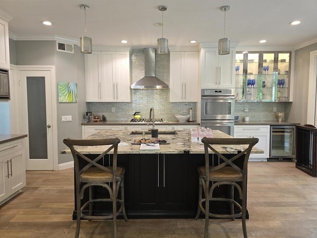 11610 Wills Creek Rd, San Diego, CA 92131 - kitchen with beverage cooler, wall chimney exhaust hood, crown molding, stainless steel appliances, and decorative backsplash