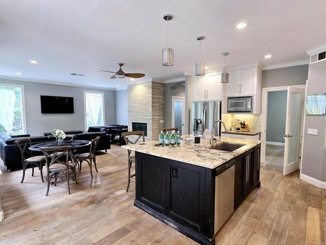 11610 Wills Creek Rd, San Diego, CA 92131 - kitchen featuring a sink, open floor plan, stainless steel appliances, ceiling fan, and white cabinetry