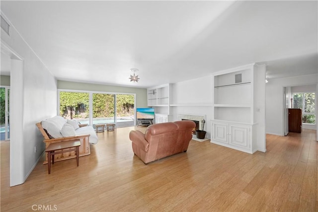 16851 Morse Cir, Huntington Beach, CA 92649 - living area with light wood-style floors, a fireplace, built in shelves, and baseboards