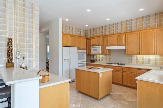 75929 Camino Cielo, Indian Wells, CA 92210 - kitchen featuring white appliances, light countertops, light tile patterned floors, a peninsula, and a kitchen island