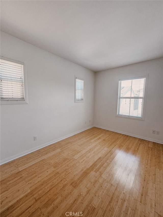 13529 Scarlet Sage Trl, San Diego, CA 92130 - empty room with healthy amount of natural light, light wood finished floors, and baseboards