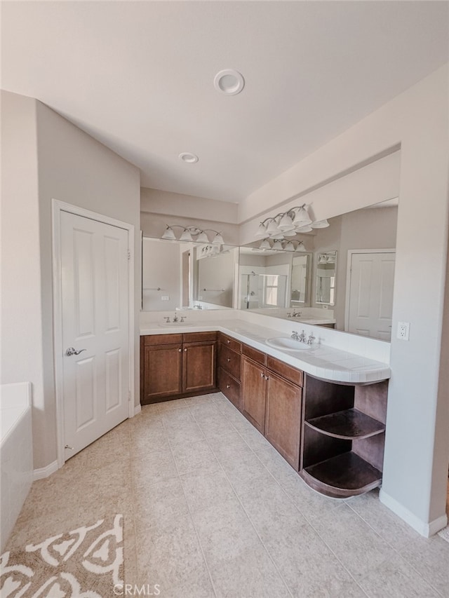 13529 Scarlet Sage Trl, San Diego, CA 92130 - bathroom featuring double vanity, tile patterned flooring, a bath, recessed lighting, and baseboards