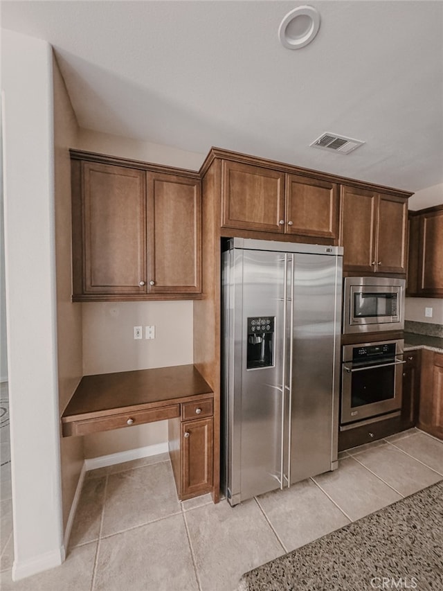 13529 Scarlet Sage Trl, San Diego, CA 92130 - kitchen featuring appliances with stainless steel finishes, light tile patterned floors, and dark countertops