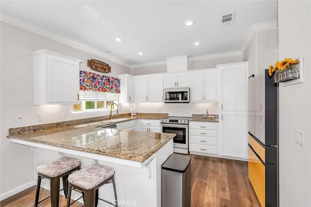3008 La Vina Cir, Los Banos, CA 93635 - kitchen with appliances with stainless steel finishes, a peninsula, crown molding, white cabinetry, and a sink