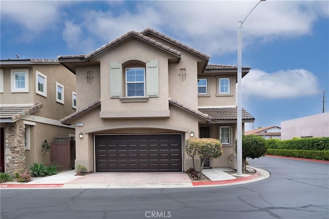 8063 Cambria Cir, Stanton, CA 90680 - townhome / multi-family property with a tiled roof, stucco siding, and an attached garage